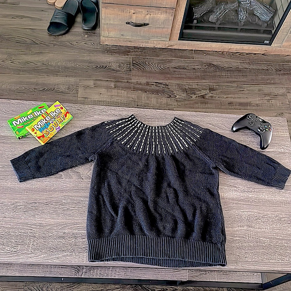 Sweater that is black but has silver details neck line.